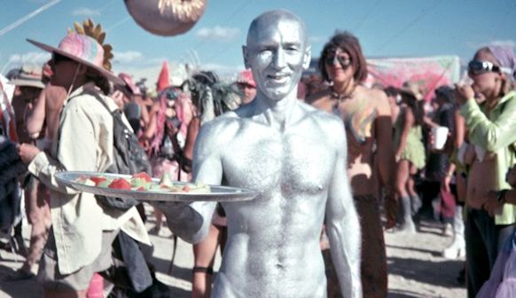 Silver Man serving fruit at Critical Tits party